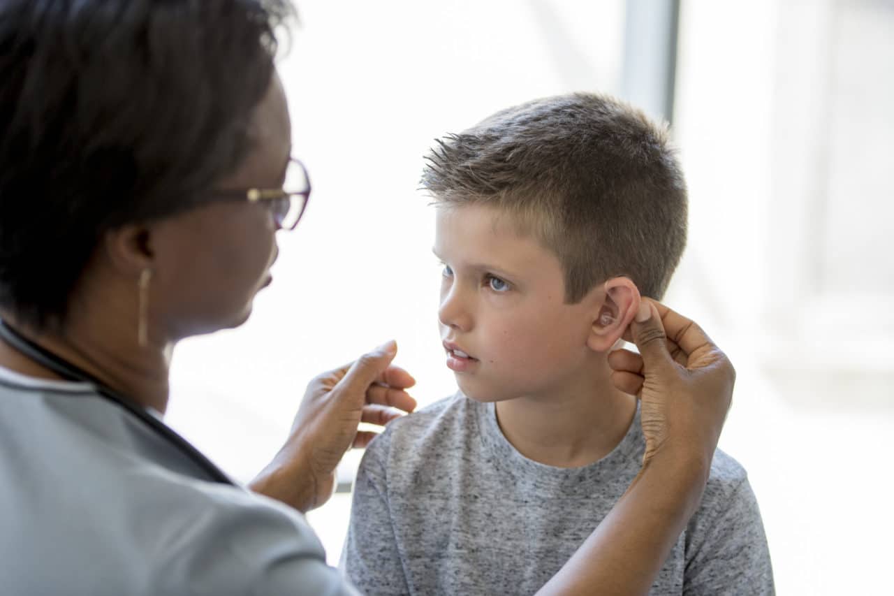 Photo of a health care provider fitting a child's hearing device