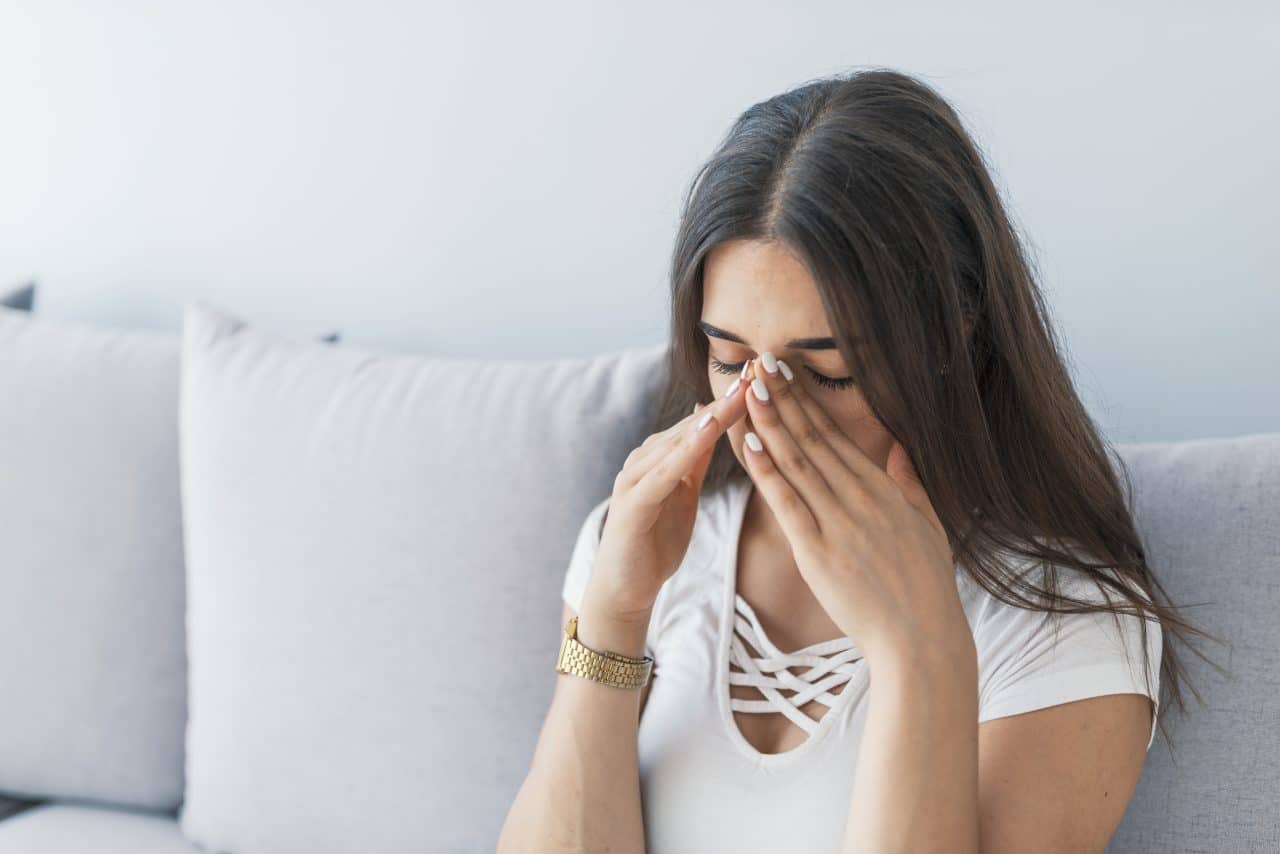 Woman experiencing sinus pain from allergies.