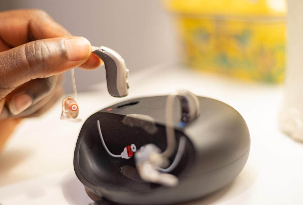 Someone docks their hearing aids on a charger.